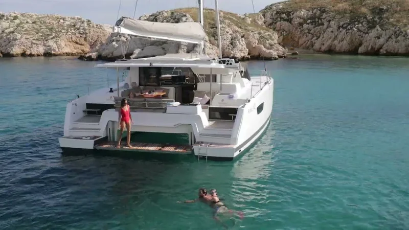 семья отдыхающая на просторной палубе катамарана в живописной бухте.