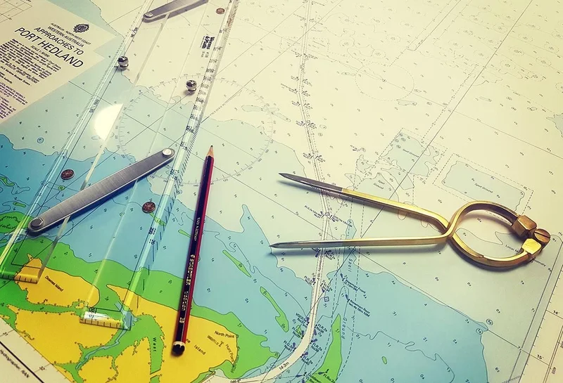Развернутая бумажная морская карта с навигационными инструментами